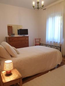 ein Schlafzimmer mit einem Bett mit einer Kommode und einem Spiegel in der Unterkunft La casa dei nonni tra Crete Senesi e Val D'Orcia in San Giovanni dʼAsso