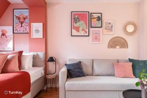 a living room with a couch and pictures on the wall at TurnKey I Letná Park Apartments in Prague
