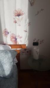 - une chambre avec un lit et une fenêtre avec un rideau de fleurs dans l'établissement La casa di Giada, à Bergame