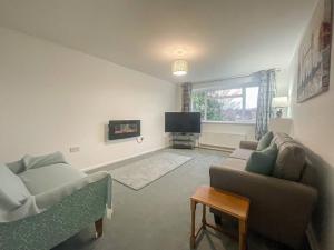 a living room with two couches and a tv at A modern one bed 1st floor apartment, Lichfield in Lichfield