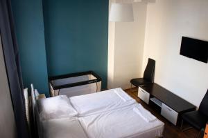 ベルリンにあるメトロポール ホステル ベルリンのベッドと椅子付きの小さな部屋です。