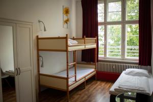 a room with two bunk beds and a window at Metropol Hostel Berlin in Berlin