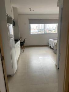 a room with a kitchen and a room with a bed at Studio metrô Belém 2 in Sao Paulo