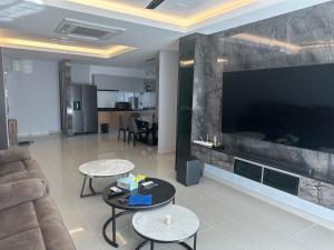 a living room with a couch and a large flat screen tv at Sri Indah condominium in Sandakan