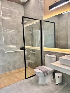 a bathroom with a shower and a toilet and a sink at Rock Resort Ratchaburi in Ratchaburi