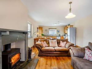 a living room with a couch and a fireplace at 3 Bed in Duddon Valley 89417 in Ulpha
