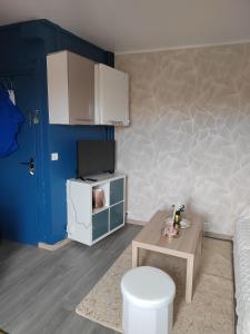 a small living room with a table and a small refrigerator at Studio proche la Défense, Cosy confort in Colombes
