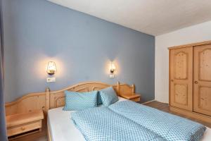 a bedroom with a bed with two blue pillows at Schwüwong - Apartment 02 in Kelchsau