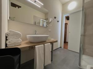 a bathroom with a sink and a mirror and towels at Dimora Conte Cavour in Vercelli