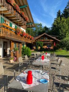 um pátio com mesas e cadeiras em frente a um edifício em Gmeinder's Landhaus em Immenstadt im Allgäu