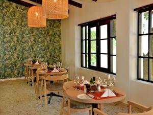 uma sala de jantar com mesas, cadeiras e janelas em ANEW Resort Hazyview Kruger Park em Hazyview