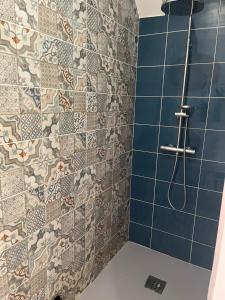 a bathroom with a shower with blue tiles at les Pastoureaux in Orléans