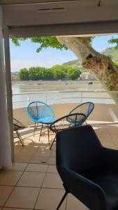 balcón con 2 sillas, mesa y ventana en Blue**** Vue exceptionnelle sur le Rhône, en Tain-lʼHermitage