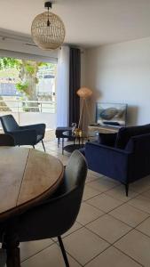 uma sala de estar com uma mesa e cadeiras e um piano em Blue**** Vue exceptionnelle sur le Rhône em Tain-lʼHermitage