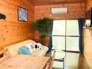 uma sala de estar com um sofá e uma mesa de vidro em Karin no oyado - Vacation STAY 30422v em Takamatsu