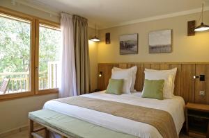 a bedroom with a large bed and a window at Domaine du Ferret Restaurant & Spa in Cap-Ferret