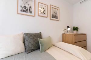 1 dormitorio con 1 cama y algunas fotos en la pared en rentafive Nuevo AA conductos Parking, en Santa Pola