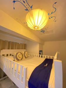 a bedroom with a white bed and a chandelier at Club Monet Beachfront Resort by Cocotel in Zambales