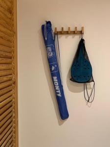 Un bate de béisbol azul y una bolsa colgando de una pared en Apartamento sobre el mar, en Salou