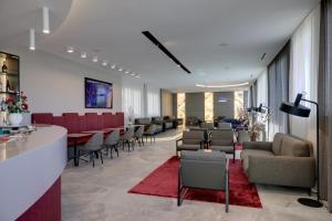 a lobby with a bar and chairs and a waiting room at Hotel Residence Zust in Verbania