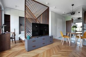 a living room with a large television and a dining table at Elite Apartments Luna Spa&Welness in Gdańsk