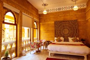 a bedroom with a bed and a table and chairs at Garh Meera - A Sensational Boutique Hotel in Jaisalmer