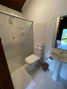 a bathroom with a shower and a toilet and a sink at Chez Max Pousada in Morro de São Paulo