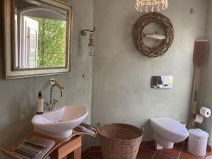 a bathroom with a sink and a toilet and a mirror at Familienurlaub im Zirkuswagen in Hümmel
