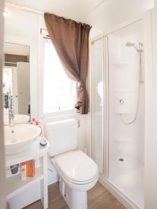 uma casa de banho com um WC, um lavatório e um chuveiro em Adria Holiday Villaggio San Francesco em Duna Verde