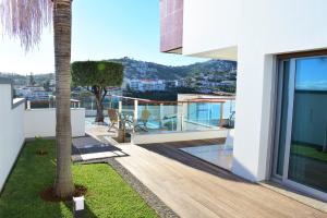 a balcony of a house with a palm tree at Moradia Vista Atlântico in Funchal