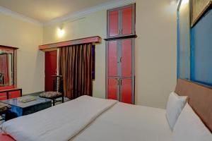 1 dormitorio con 1 cama y puertas correderas rojas en Super OYO Hotel Ram Ji Vatika, en Datia