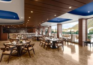 a restaurant with tables and chairs and a bar at jüSTa Sajjangarh Resort & Spa, Udaipur in Udaipur