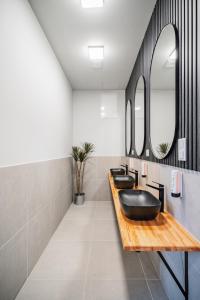 a bathroom with three sinks and two mirrors at CUBES by Tegetthoff in Vienna