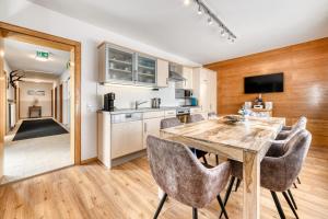 een keuken en eetkamer met een houten tafel en stoelen bij FeWo mit 3 Schlafzimmern und Balkon - Galgenul in Galgenul