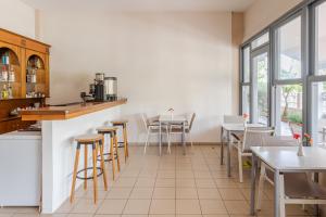 a restaurant with tables and chairs and windows at Hotel Grekas in Nei Poroi