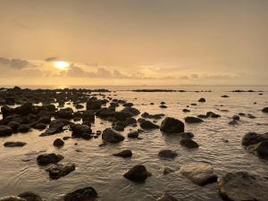 a group of rocks in the water at sunset at Nautilus Right on the Beach - Adult Only - SHA Extra Plus in Ko Lanta