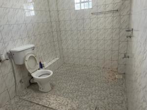 a bathroom with a toilet and a tiled floor at Serene 2 Bedrooms Apartment in Kericho