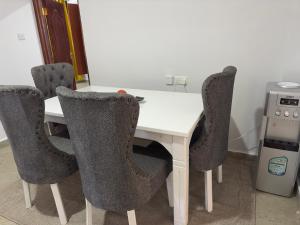 a white table with four chairs around it at Serene 2 Bedrooms Apartment in Kericho