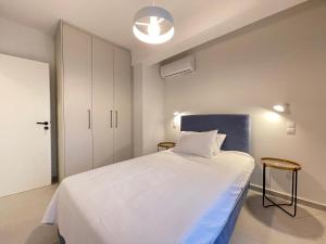 une chambre avec un grand lit et une tête de lit bleue dans l'établissement Gleaming apartments near Athens Metro Mall, à Athènes