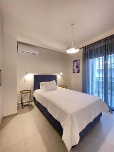 - une chambre avec un grand lit et une fenêtre dans l'établissement Gleaming apartments near Athens Metro Mall, à Athènes