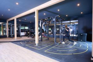 une femme qui roule dans une salle de sport équipée de machines dans l'établissement Gronenberger Mühle Haus 03, à Scharbeutz