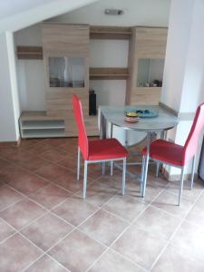 a kitchen with a table and two red chairs at Mansardina Sassu in Alghero