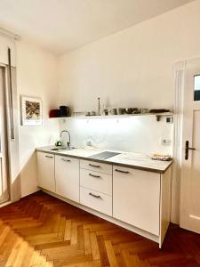 una cucina con mobili bianchi e un lavandino di Townhouse Bozen a Bolzano