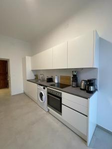 a kitchen with a stove and a washing machine at Rochus Stylish Stays in Vienna
