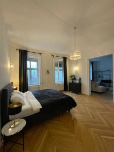 a bedroom with a large bed and a living room at Rochus Stylish Stays in Vienna