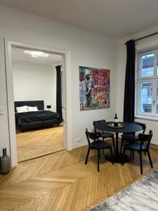 a living room with a table and chairs and a bed at Rochus Stylish Stays in Vienna