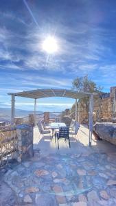 un patio con mesa y sillas bajo un dosel en Al khitaym guest house, en Sa‘ab Banī Khamīs