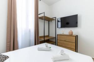 sypialnia z dwoma łóżkami i telewizorem na ścianie w obiekcie Stockholm/St-Lazare w Paryżu