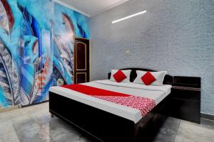 1 dormitorio con 1 cama con una pintura en la pared en OYO Flagship Riddhi Siddhi Guest House, en Rudrapur