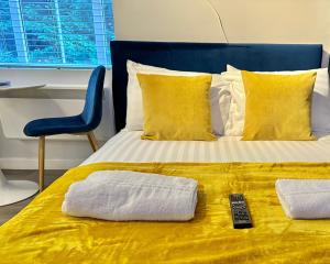 a bed with two towels and a remote control on it at Serenity Retreat - Tranquil Apartment Close to Beach in Bournemouth